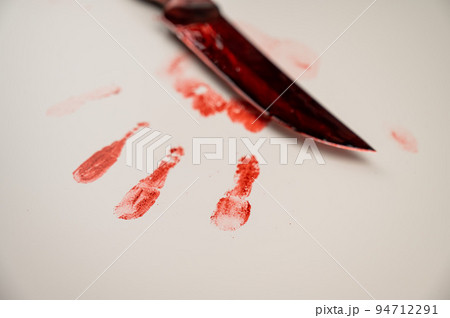 Bloody knife and hand prints in blood on a white table. Bloody knife and hand prints in blood on a white table. 94712291