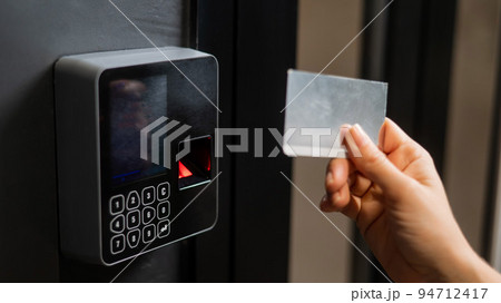 A woman opens the door with a plastic card. Modern keyless entry lock. A woman opens the door with a plastic card. Modern keyless entry lock. 94712417