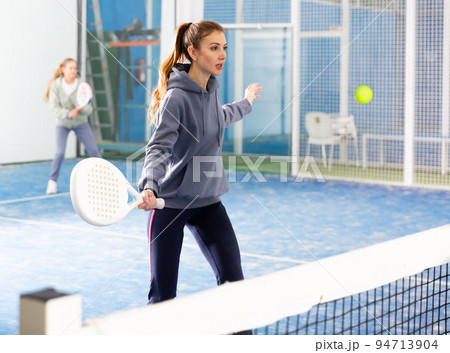 Woman playing padel tennis on padel court Woman playing padel tennis on padel court 94713904