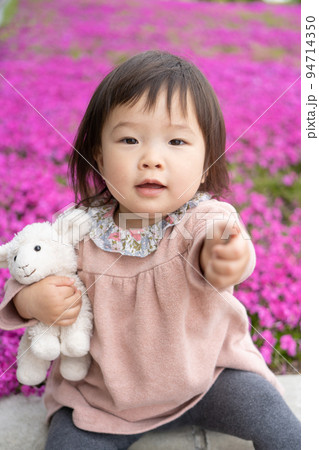 お花畑でぬいぐるみを抱いて座る小さな女の子 お花畑でぬいぐるみを抱いて座る小さな女の子 94714350