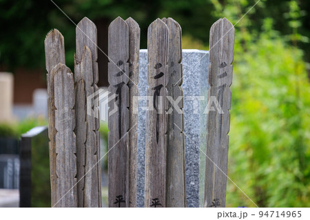 墓に立てられた日に焼けた古い塔婆 94714965