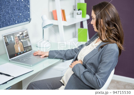 Caucasian businesswoman sitting at desk using laptop having video call with female colleague 94715530