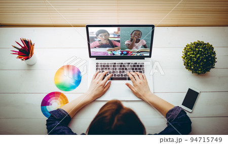 Caucasian girl sitting at desk using laptop to talk to friends 94715749