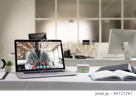 African american man having video call on screen of laptop on desk African american man having video call on screen of laptop on desk 94715767