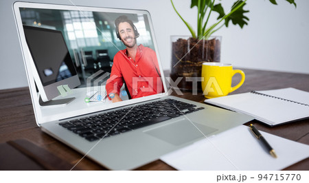 Caucasian man having video call on screen of laptop on desk Caucasian man having video call on screen of laptop on desk 94715770