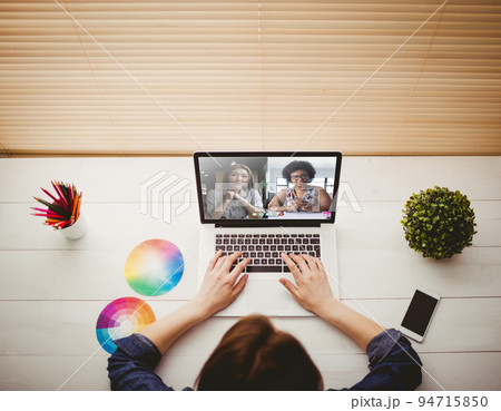 Caucasian girl sitting at desk having video call Caucasian girl sitting at desk having video call 94715850