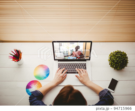 Caucasian businesswoman sitting at desk using laptop having video call with female colleague Caucasian businesswoman sitting at desk using laptop having video call with female colleague 94715966