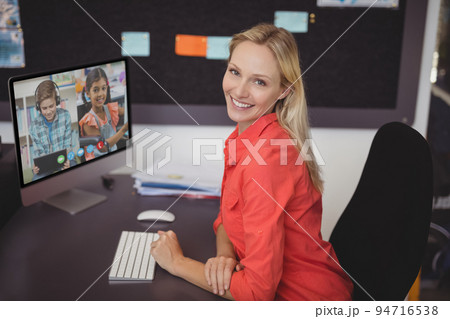 Portrait of female caucasian teacher having a video conference with male and female student on compu 94716538