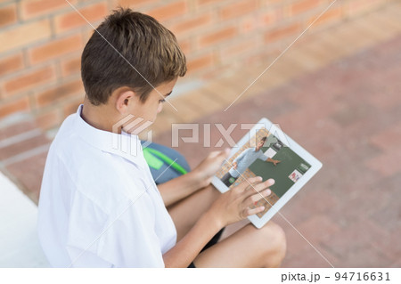 Caucasian schoolboy using digital tablet on video call with male teacher Caucasian schoolboy using digital tablet on video call with male teacher 94716631