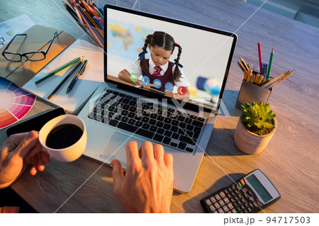 Caucasian schoolgirl learning displayed on laptop screen during video call with male teacher 94717503