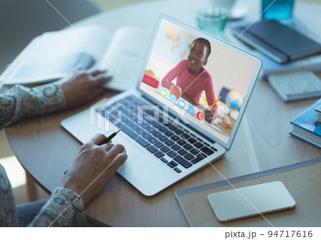 African american schoolgirl learning displayed on laptop screen during video call with female teache African american schoolgirl learning displayed on laptop screen during video call with female teache 94717616