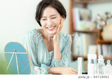 笑顔で鏡を見る女性 94718002