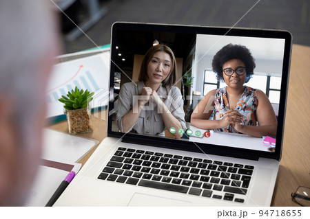 Diverse businesswomen displayed on laptop screen during office video call 94718655