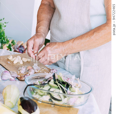 A woman is engaged in the preparation and processing of various fresh farm vegetables 94722465