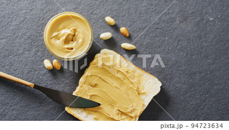 Image of close up of toast with peanut butter on gray background Image of close up of toast with peanut butter on gray background 94723634
