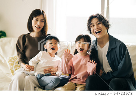 ソファに座る笑顔の家族・子育てイメージ ソファに座る笑顔の家族・子育てイメージ 94723978