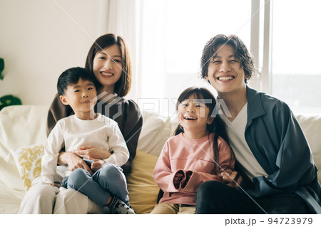 ソファに座る笑顔の家族・子育てイメージ ソファに座る笑顔の家族・子育てイメージ 94723979
