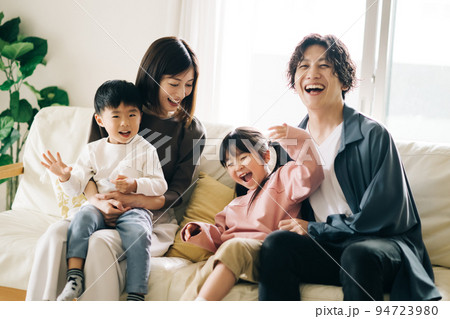 ソファに座る笑顔の家族・子育てイメージ 94723980