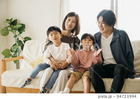 ソファに座る笑顔の家族・子育てイメージ 94723994