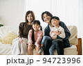 ソファに座る笑顔の家族・子育てイメージ 94723996
