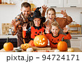 Happy family parents and kids does scary gesture, while make jack-o-lantern from pumpkin, getting ready for halloween 94724171