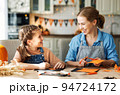 Happy smiling family mother and daughter making Halloween home decorations together 94724172