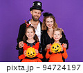 Cheerful family in carnival costumes celebrate Halloween on colored purple background 94724197