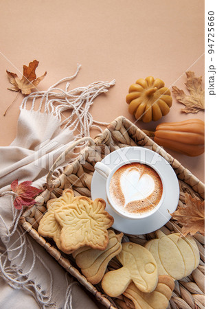 Cup of coffee, cookies on tray, yellow leaves. 94725660