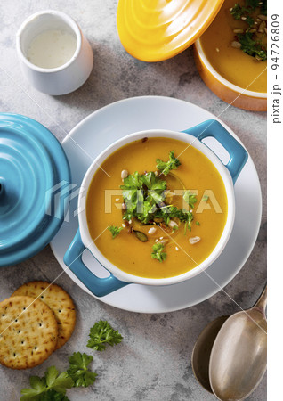 Pumpkin or butternut squash autumn creamy soup, blue bowl, grey background Pumpkin or butternut squash autumn creamy soup, blue bowl, grey background 94726809