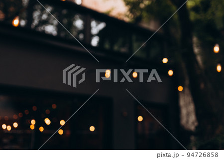 Decorative outdoor string lights, Defocused Background, night city life backdrop, party time with Yellow bokeh balls 94726858