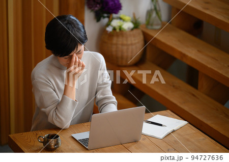 パソコンで眼精疲労を気にする女性 パソコンで眼精疲労を気にする女性 94727636