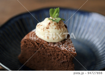 生クリームにミントを飾ったカットしたガトーショコラ 生クリームにミントを飾ったカットしたガトーショコラ 94727898