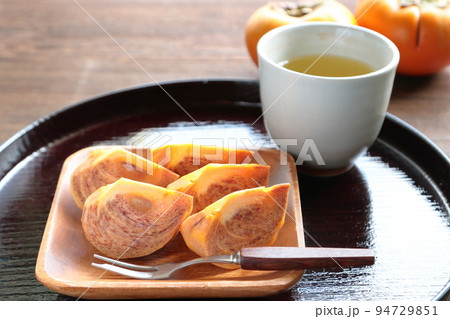 カットされた柿とお茶　早生柿 94729851