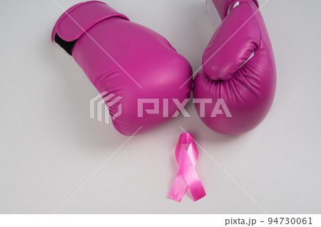 Pink boxing gloves and a pink silk ribbon on a white background. Breast cancer concept. Pink boxing gloves and a pink silk ribbon on a white background. Breast cancer concept. 94730061