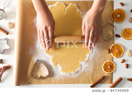 Woman cooking cookies, using cookie cutter and rolling pin Woman cooking cookies, using cookie cutter and rolling pin 94730469