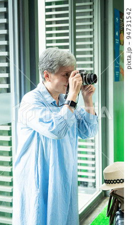 Portrait of happy senior adult elderly asia woman 60s taking pictures with photo camera for travel concept. 94731542