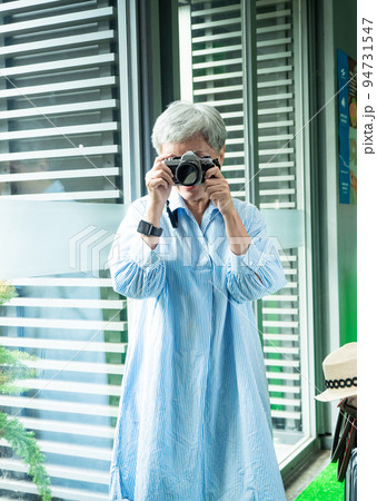 Portrait of happy senior adult elderly asia woman 60s taking pictures with photo camera for travel concept. 94731547