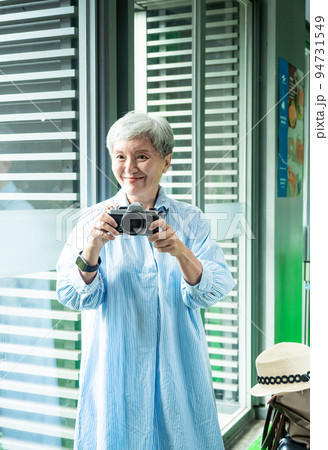 Portrait of happy senior adult elderly asia woman 60s taking pictures with photo camera for travel concept. 94731549