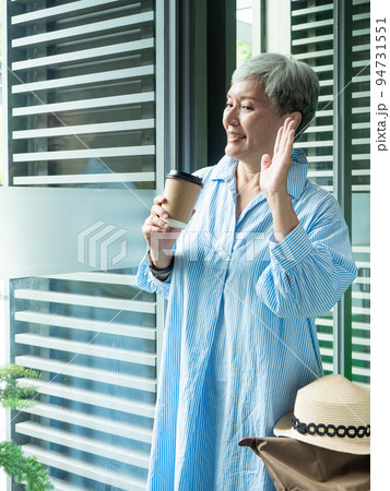 Portrait of happy senior adult elderly asia woman 60s holding paper cup, drinking coffee for travel concept. 94731551