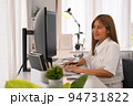 Smiling young woman working on software development on desktop computer at modern office 94731822
