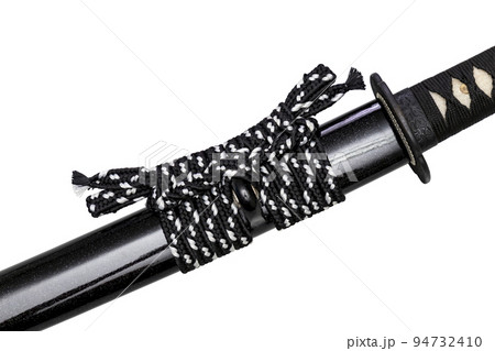 Close up shot of Sageo - Thick black-white silk rope for tying the scabbard of Japanese swords. It was a rope for the samurai to tie at the waist. isolated on white background. Selective focus. Close up shot of Sageo - Thick black-white silk rope for tying the scabbard of Japanese swords. It was a rope for the samurai to tie at the waist. isolated on white background. Selective focus. 94732410