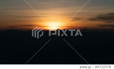The sun is rising or setting on the horizon 94732576
