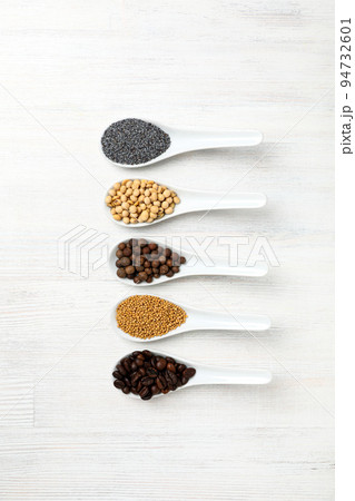Spoons with different food on white wooden background Spoons with different food on white wooden background 94732601