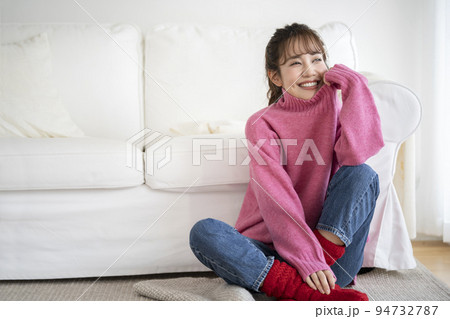 ピンクのセーターを着た笑顔の若い女性 ピンクのセーターを着た笑顔の若い女性 94732787