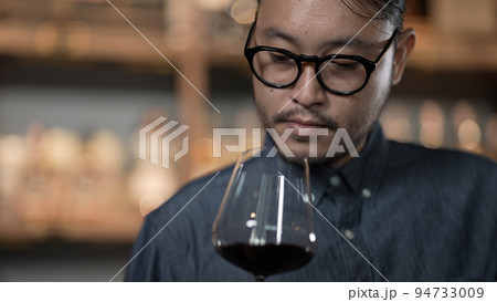 Night club concept of 4k Resolution. Asian man tasting wine in a restaurant. A group of specialized clubs that sell alcoholic beverages. 94733009
