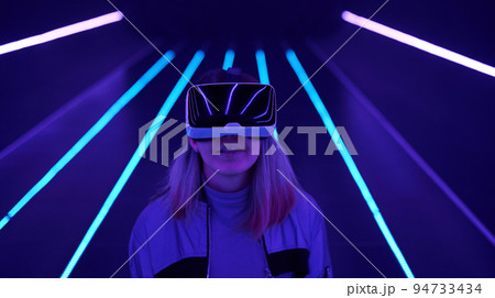 Woman is using virtual reality headset to access in metaverse. Woman is using virtual reality headset to access in metaverse. 94733434