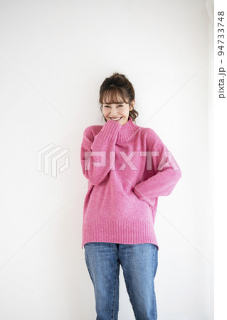 ピンクのセーターを着た笑顔の若い女性 ピンクのセーターを着た笑顔の若い女性 94733748