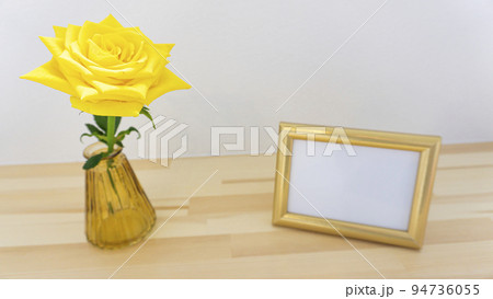テーブルの上に飾られた写真立てと花 94736055