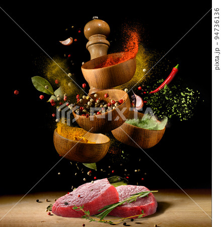 Raw meat steaks and spices on black Raw meat steaks and spices on black 94736136