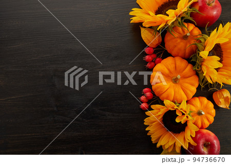Pumpkin and sunflowers over old wooden background with copy space. Autumn background decoration. Pumpkin and sunflowers over old wooden background with copy space. Autumn background decoration. 94736670